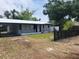 Cozy single-story home with a metal roof, carport, picket fence and fresh landscaping at 4210 Baird St, Sarasota, FL 34232