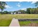 Large backyard with a building, trailers, equipment, and a wooden walkway leading to a concrete structure at 4225 Ulman Ave, North Port, FL 34286