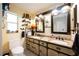 Bathroom featuring double sinks, granite countertops, and decorative mirrors at 4225 Ulman Ave, North Port, FL 34286