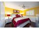 Bright bedroom with yellow walls, a ceiling fan, hardwood floors, and ample natural light at 4225 Ulman Ave, North Port, FL 34286