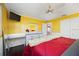 Sunny bedroom featuring bright yellow walls, an entertainment unit, and white trim at 4225 Ulman Ave, North Port, FL 34286