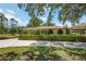 Well-maintained home with manicured landscaping, a long driveway, and mature trees at 4225 Ulman Ave, North Port, FL 34286