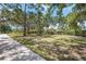 Lush green property with a long driveway, landscaping, mature trees, and a house in the distance at 4225 Ulman Ave, North Port, FL 34286