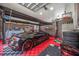 This garage features a black sports car on a stylish red and black tile floor at 4225 Ulman Ave, North Port, FL 34286