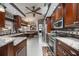 Gourmet kitchen featuring granite countertops, stainless steel appliances, and rich wood cabinetry at 4225 Ulman Ave, North Port, FL 34286