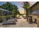 Outdoor patio area with lounge chairs, tiki bar and path leading to a lake view at sunset at 4225 Ulman Ave, North Port, FL 34286