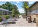Outdoor lounge with wicker seating, tiki bar, lush landscaping, and scenic pathway leading to water at 4225 Ulman Ave, North Port, FL 34286
