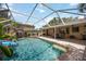 Screened-in pool area with a waterfall feature, slide, and ample patio space for relaxation at 4225 Ulman Ave, North Port, FL 34286