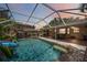 Screened-in pool area with a waterfall feature, slide, and ample patio space for relaxation at 4225 Ulman Ave, North Port, FL 34286