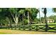 Expansive lush green yard featuring an elegant black fence and mature trees offering shaded privacy at 4225 Ulman Ave, North Port, FL 34286
