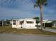 Cozy mobile home with well-maintained landscaping, carport, and inviting curb appeal in a quiet neighborhood at 5119 Glen Echo Ave, Sarasota, FL 34234