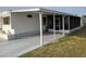 Cozy mobile home with a covered patio, offering a screened-in area for outdoor relaxation and entertainment at 5119 Glen Echo Ave, Sarasota, FL 34234