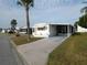 Well-kept mobile home with a long driveway, carport, and landscaped yard providing convenient parking and outdoor space at 5119 Glen Echo Ave, Sarasota, FL 34234
