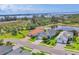 Aerial view of lovely homes with well-maintained lawns, a pond, and green trees surrounding the neighborhood at 523 Wildlife Gln, Bradenton, FL 34209