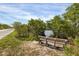 A bench sits next to a paved trail and a waterfront with trees and bushes in the background at 523 Wildlife Gln, Bradenton, FL 34209