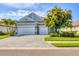 Charming home featuring a well-manicured lawn, a stone-accented facade, and a spacious three-car garage at 523 Wildlife Gln, Bradenton, FL 34209