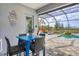 Screened-in patio with a colorful outdoor dining set, a scenic view, and access to the pool at 523 Wildlife Gln, Bradenton, FL 34209
