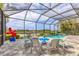 Screened-in pool area with comfortable seating, scenic views, and a serene waterfront setting at 523 Wildlife Gln, Bradenton, FL 34209