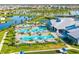 Aerial view of a community clubhouse, pools, basketball court and surrounding houses and waterways at 5333 Coral Reef Way, Bradenton, FL 34211