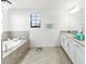 Bathroom featuring a soaking tub, double vanity with granite counters, tile flooring and modern fixtures at 5333 Coral Reef Way, Bradenton, FL 34211
