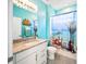 Stylish bathroom featuring coastal-themed decor, a vanity with granite countertops, and a tropical shower curtain at 5333 Coral Reef Way, Bradenton, FL 34211