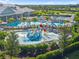 A vibrant aerial view of the community pool featuring a playful splash area and comfortable lounge seating at 5333 Coral Reef Way, Bradenton, FL 34211
