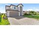 Charming two-story home with a two-car garage, nicely landscaped yard, and paver driveway under a blue sky at 5333 Coral Reef Way, Bradenton, FL 34211