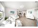 Open concept living space with tile floors, white furnishings, shiplap accent wall and access to the kitchen at 5333 Coral Reef Way, Bradenton, FL 34211
