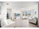 Bright living room with tile flooring, white furniture, modern shelving, and a waterfront view at 5333 Coral Reef Way, Bradenton, FL 34211