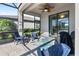 Cozy screened patio with a ceiling fan, comfortable seating, and views of the lush backyard at 5333 Coral Reef Way, Bradenton, FL 34211
