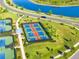 Aerial shot showing multiple pickleball courts with lights, seating, and lush landscaping at 5333 Coral Reef Way, Bradenton, FL 34211