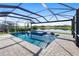 Screened pool with spa and lake views; features lounge chairs and tiled patio for relaxation and enjoyment at 5333 Coral Reef Way, Bradenton, FL 34211