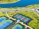 Aerial view of green and blue tennis courts with pickleball courts and scenic landscaping at 5333 Coral Reef Way, Bradenton, FL 34211
