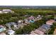 A broad aerial perspective of a residential area with diverse home styles, trees, and an expansive green forested area at 553 Meadow Sweet Cir, Osprey, FL 34229