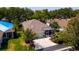 A beautiful overhead view of a well-maintained home with a screened lanai, lush landscaping, and a spacious driveway at 553 Meadow Sweet Cir, Osprey, FL 34229
