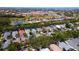 Expansive aerial view of a residential community featuring numerous homes, a pond, and commercial buildings in the distance at 553 Meadow Sweet Cir, Osprey, FL 34229