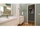 Contemporary bathroom with double sinks, modern cabinets and decorative accents, all complemented by wood-style flooring at 553 Meadow Sweet Cir, Osprey, FL 34229