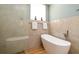 Elegant bathroom with a modern standalone tub, a glass shower enclosure, and refined tile work at 553 Meadow Sweet Cir, Osprey, FL 34229