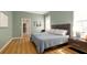 Serene bedroom with hardwood floors, a queen bed, minimalist decor, and ample natural light through a large window at 553 Meadow Sweet Cir, Osprey, FL 34229