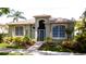 Charming single-story home boasts a secure gated entrance, lush landscaping, and large windows that flood the space with natural light at 553 Meadow Sweet Cir, Osprey, FL 34229