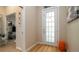 Bright foyer with wood-look flooring, a glass paneled front door, and an orange accent stool at 553 Meadow Sweet Cir, Osprey, FL 34229