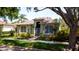 Inviting front yard with mature trees, lush landscaping, and well-maintained lawn at 553 Meadow Sweet Cir, Osprey, FL 34229