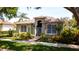 Lovely one-story home featuring an arched entryway, decorative security gate, and beautifully landscaped yard at 553 Meadow Sweet Cir, Osprey, FL 34229