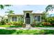 Charming one-story home showcasing lush landscaping, an arched entryway, and a secure decorative gate at 553 Meadow Sweet Cir, Osprey, FL 34229