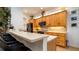Bright kitchen featuring light wood cabinets, stone countertops, backsplash, and an island with bar stool seating at 553 Meadow Sweet Cir, Osprey, FL 34229