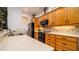 A close up of the kitchen with granite countertops and backsplash, light wood cabinets, and black appliances at 553 Meadow Sweet Cir, Osprey, FL 34229