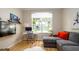 Bright, modern living room featuring a large window, sleek desk, television, and comfortable sectional sofa at 553 Meadow Sweet Cir, Osprey, FL 34229