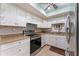 Clean kitchen design with white cabinets, stainless steel appliances, and light countertops, maximizing functionality and style at 5709 13Th W Ave, Bradenton, FL 34209