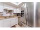 Bright kitchen featuring stainless steel refrigerator, white cabinets, and modern fixtures for a clean, efficient cooking space at 5709 13Th W Ave, Bradenton, FL 34209