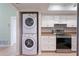 Well-organized kitchen includes modern appliances, white cabinetry, and a convenient laundry area for efficient home management at 5709 13Th W Ave, Bradenton, FL 34209